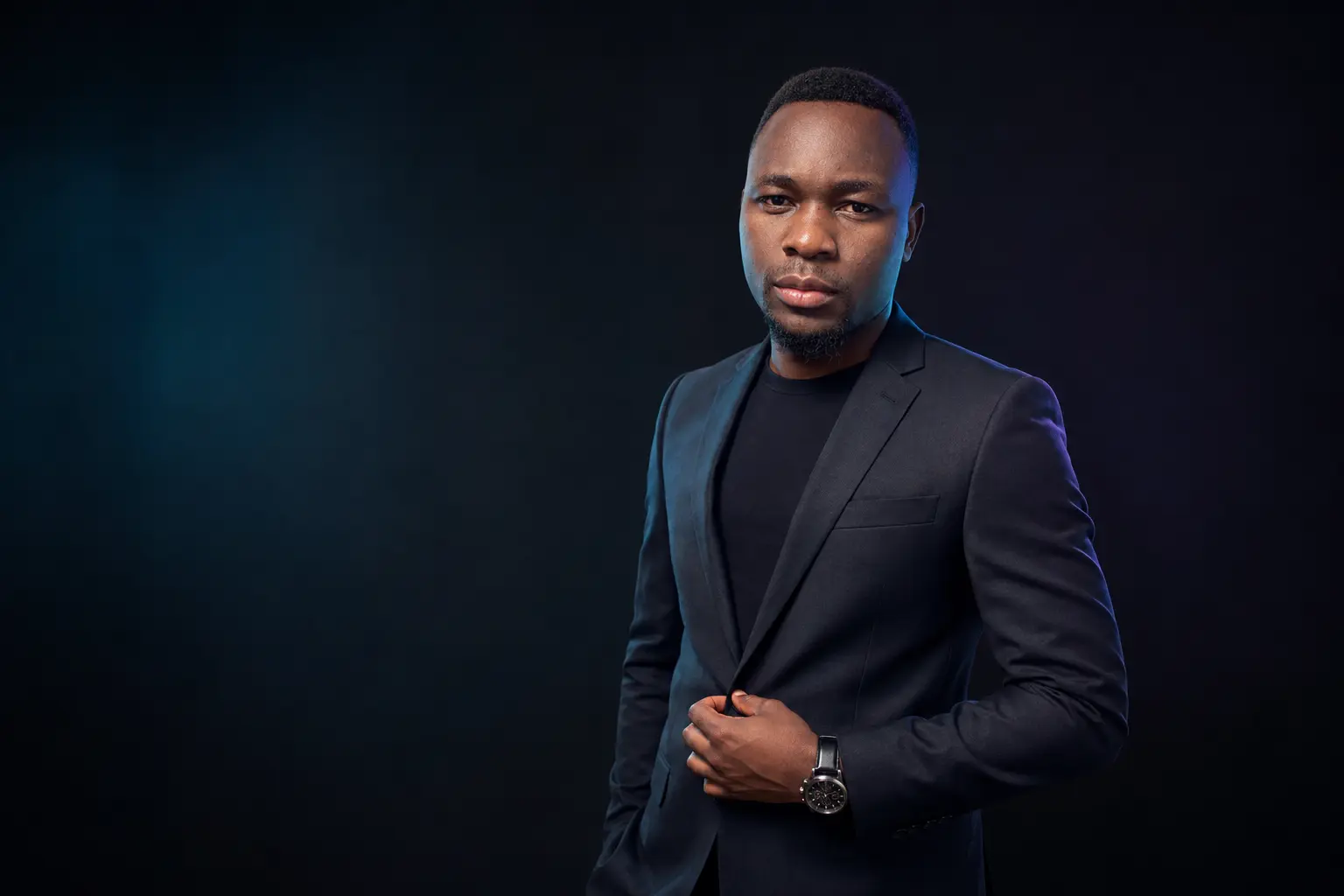 Zabron Amon Zabron in a black suit in a dark studio